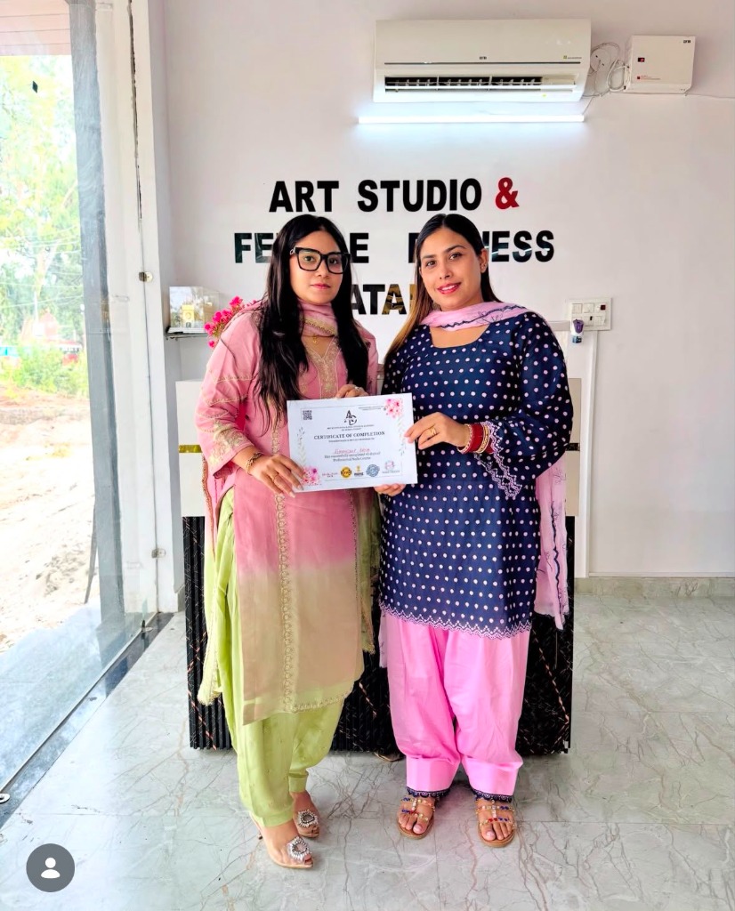 Student holding Certificate of Completion with academy representative at Art Studio Batala